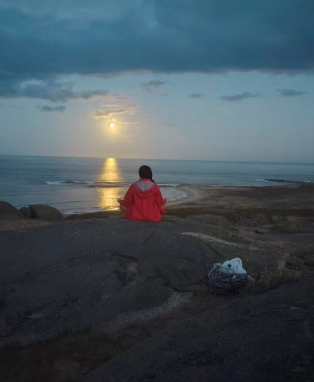 Natalia Márquez meditando frente al mar al amanecer